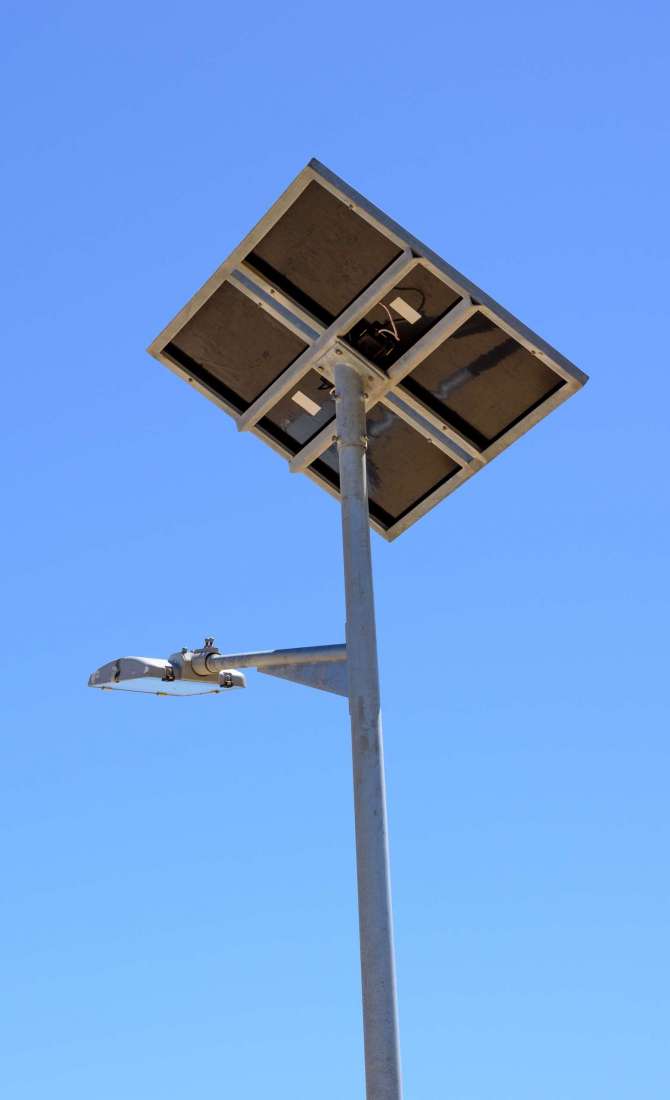Street light with solar panel on blue sky background. Green energy.